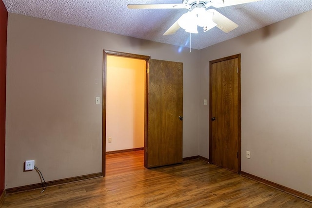 unfurnished bedroom with hardwood / wood-style flooring, ceiling fan, and a textured ceiling