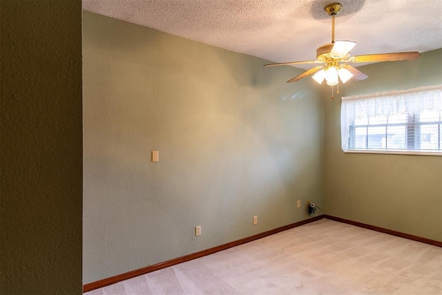 carpeted spare room featuring ceiling fan and a textured ceiling