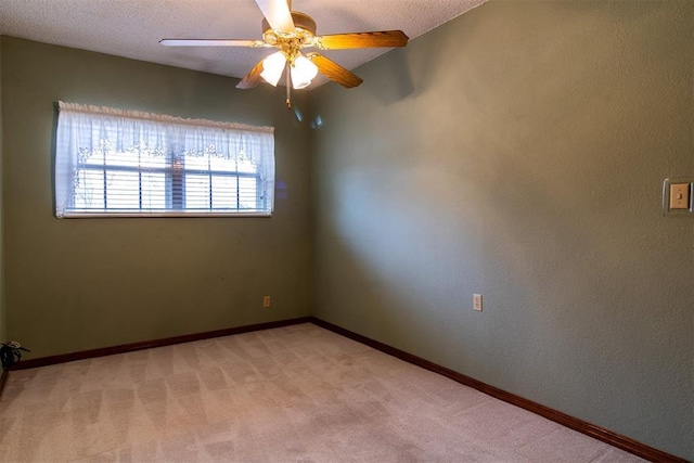 carpeted spare room featuring ceiling fan and a textured ceiling