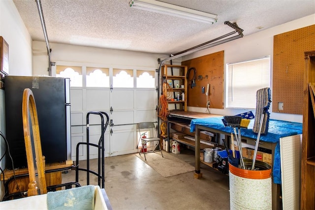 garage featuring stainless steel fridge and a workshop area