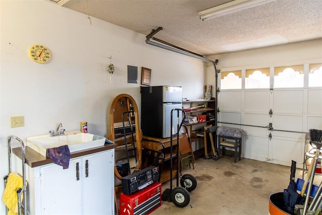 garage with stainless steel refrigerator and sink