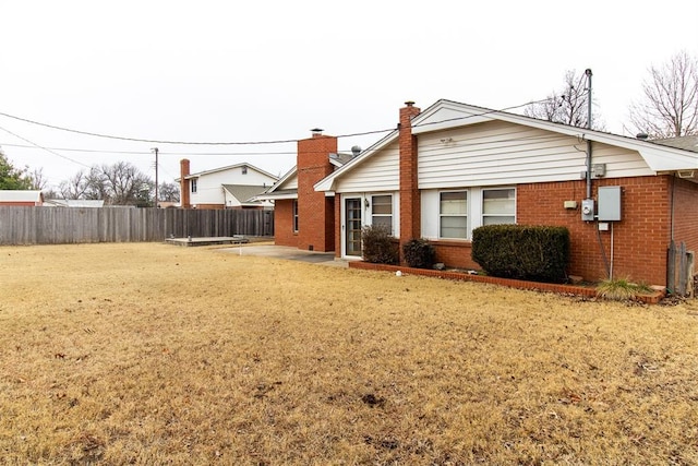 back of house featuring a lawn