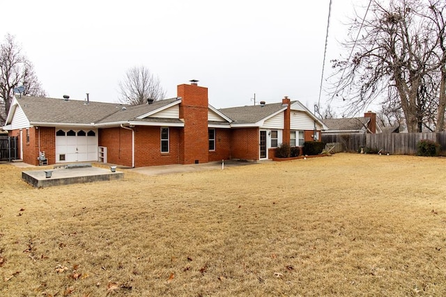 rear view of house with a garage and a lawn