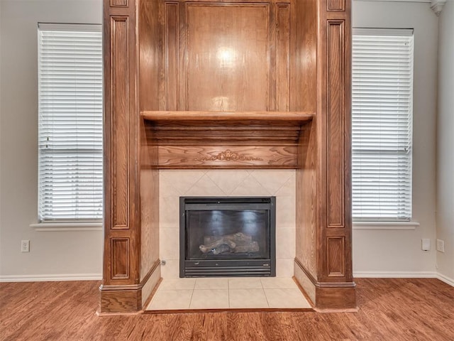 interior details featuring wood-type flooring and a tile fireplace