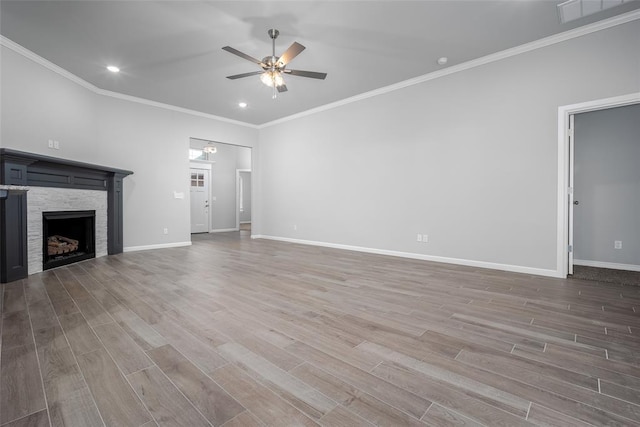 unfurnished living room featuring hardwood / wood-style flooring, ceiling fan, ornamental molding, and a fireplace