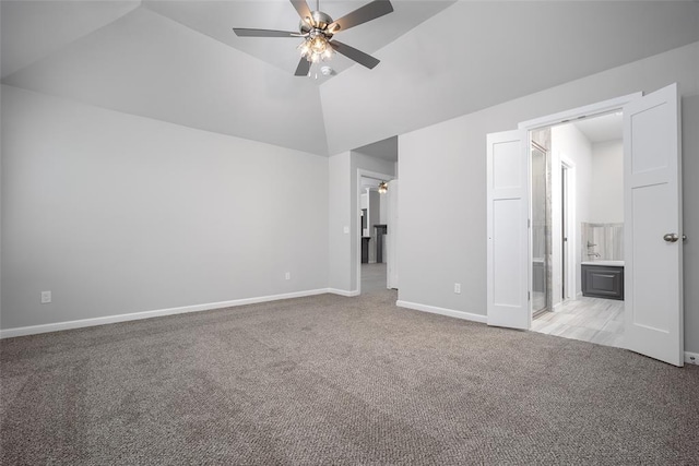 unfurnished bedroom with vaulted ceiling, connected bathroom, light colored carpet, and ceiling fan