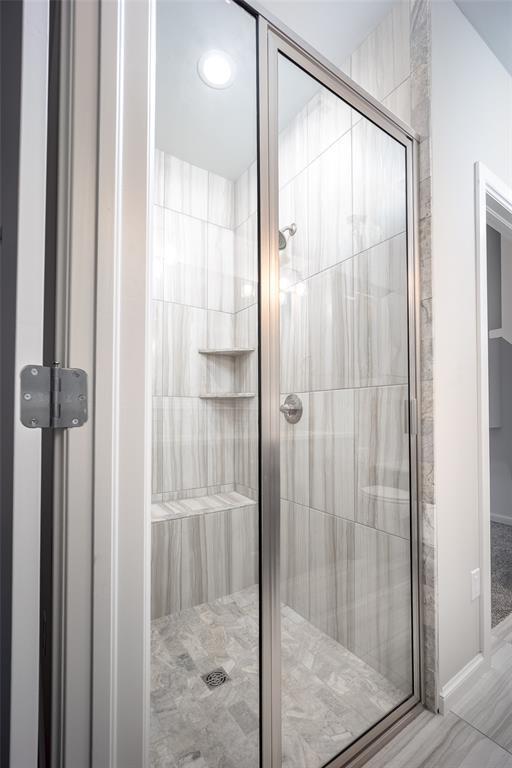 bathroom featuring a shower with door