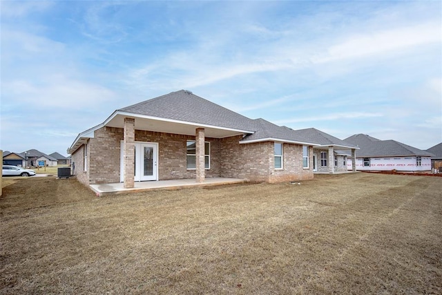 back of house with cooling unit, a yard, and a patio area