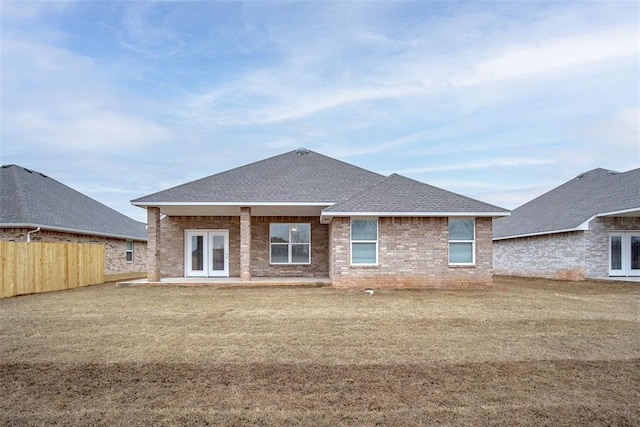 rear view of property featuring a lawn and french doors