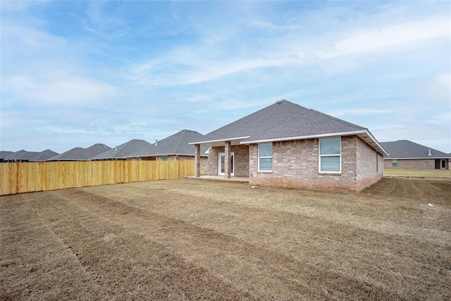 rear view of property with a lawn