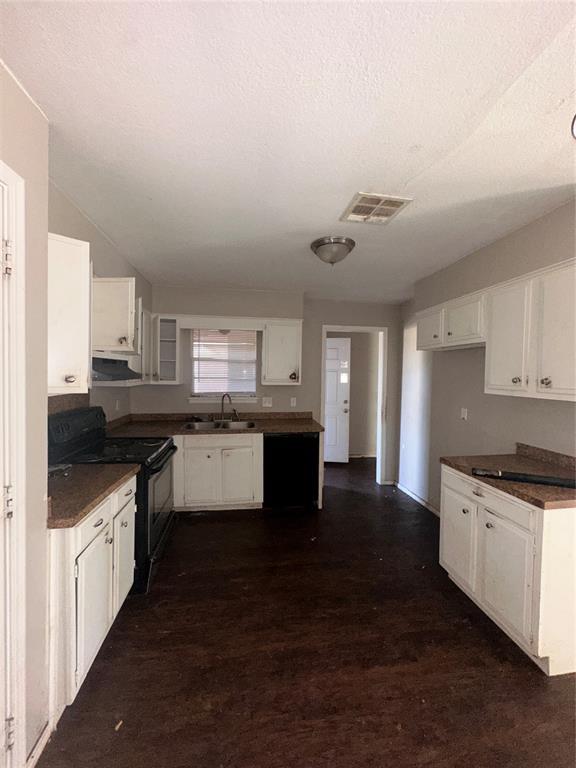 kitchen featuring sink, a textured ceiling, dark hardwood / wood-style floors, black range, and white cabinets