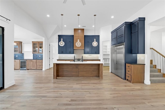 kitchen featuring sink, stainless steel built in fridge, pendant lighting, beverage cooler, and light hardwood / wood-style floors