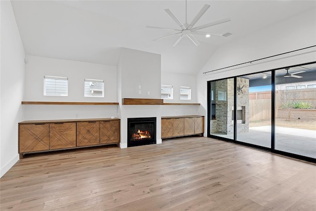 unfurnished living room with ceiling fan, lofted ceiling, and light hardwood / wood-style flooring