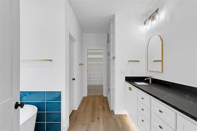 bathroom featuring vanity, hardwood / wood-style floors, and a bathing tub