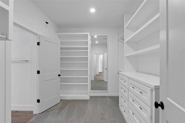 walk in closet featuring light colored carpet