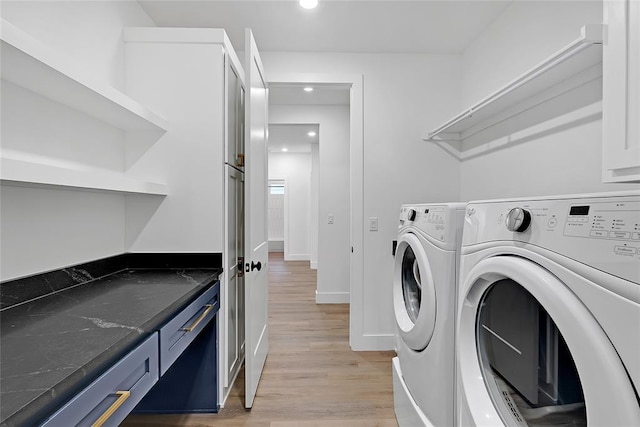 laundry room with separate washer and dryer and light hardwood / wood-style floors