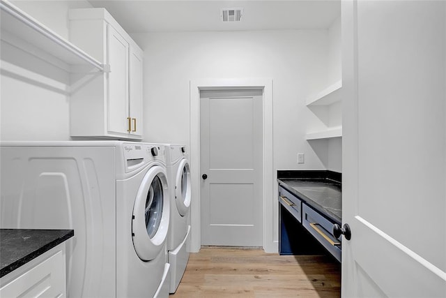 laundry area featuring cabinets, washer and dryer, and light wood-type flooring