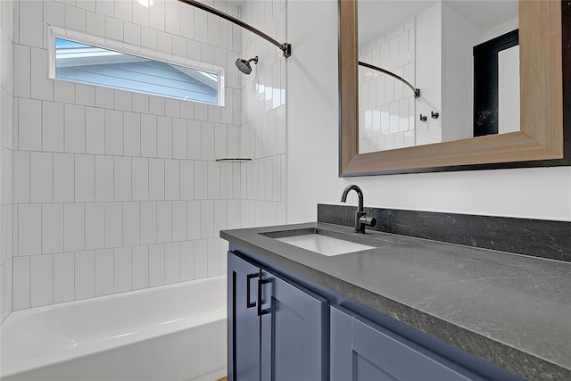 bathroom featuring tiled shower / bath combo and vanity