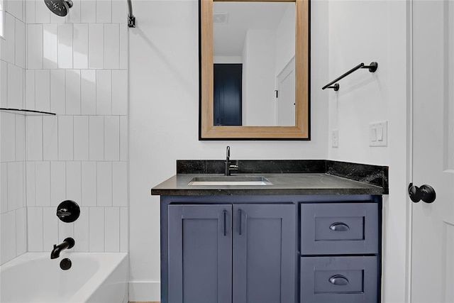 bathroom with tiled shower / bath and vanity