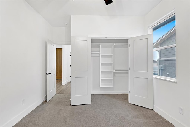 unfurnished bedroom with light colored carpet and a closet