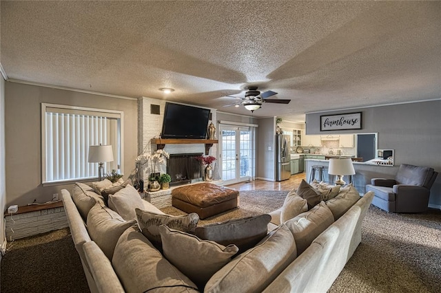 living room featuring french doors, ornamental molding, a brick fireplace, and a textured ceiling