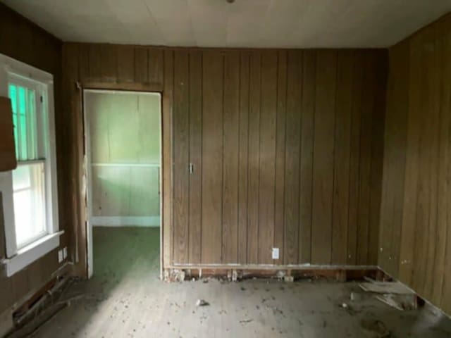 unfurnished room featuring wood walls