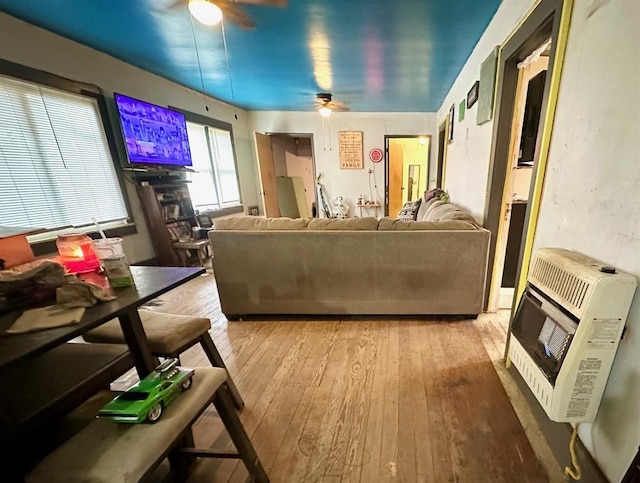 living room with ceiling fan, hardwood / wood-style floors, and heating unit