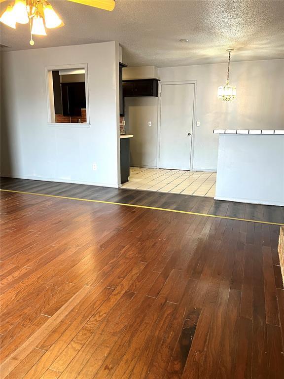 empty room featuring ceiling fan, dark hardwood / wood-style floors, and a textured ceiling