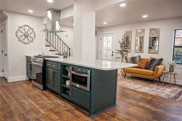 kitchen with dark hardwood / wood-style flooring, stainless steel appliances, green cabinetry, and island exhaust hood