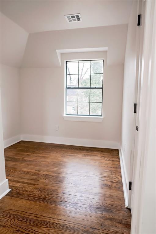 additional living space featuring lofted ceiling and dark hardwood / wood-style flooring