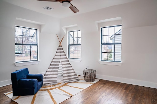 sitting room featuring plenty of natural light, dark hardwood / wood-style floors, and ceiling fan