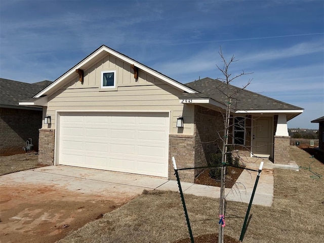 single story home featuring concrete driveway, a shingled roof, board and batten siding, and an attached garage