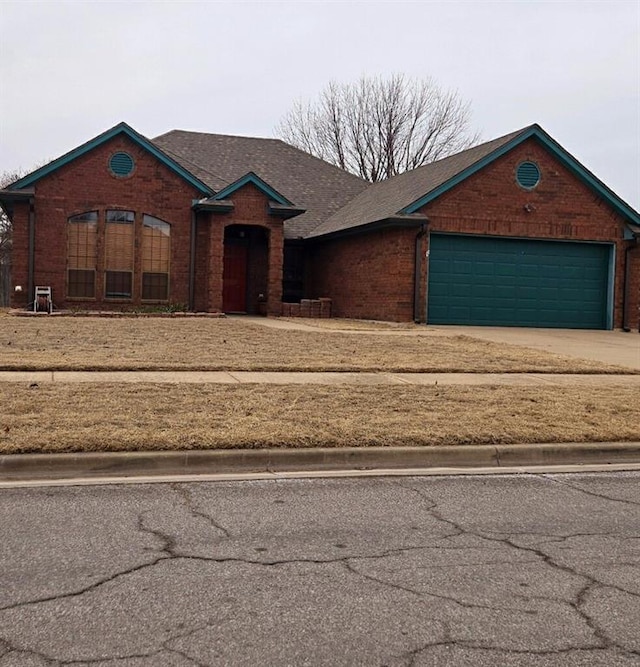 view of front of property featuring brick siding and concrete driveway