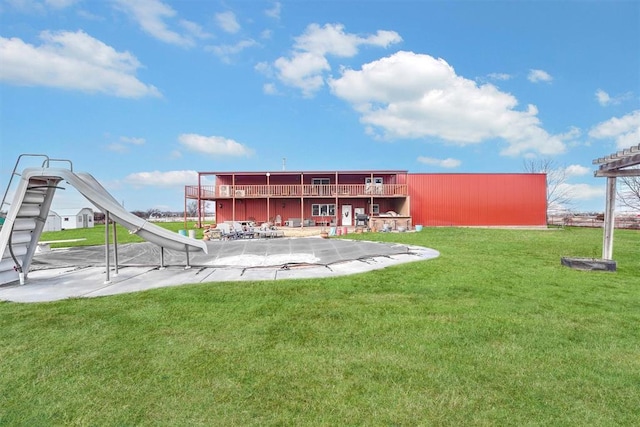 exterior space featuring a patio, a wooden deck, and a lawn