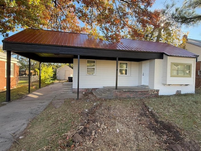 view of front of home with a storage shed and a carport