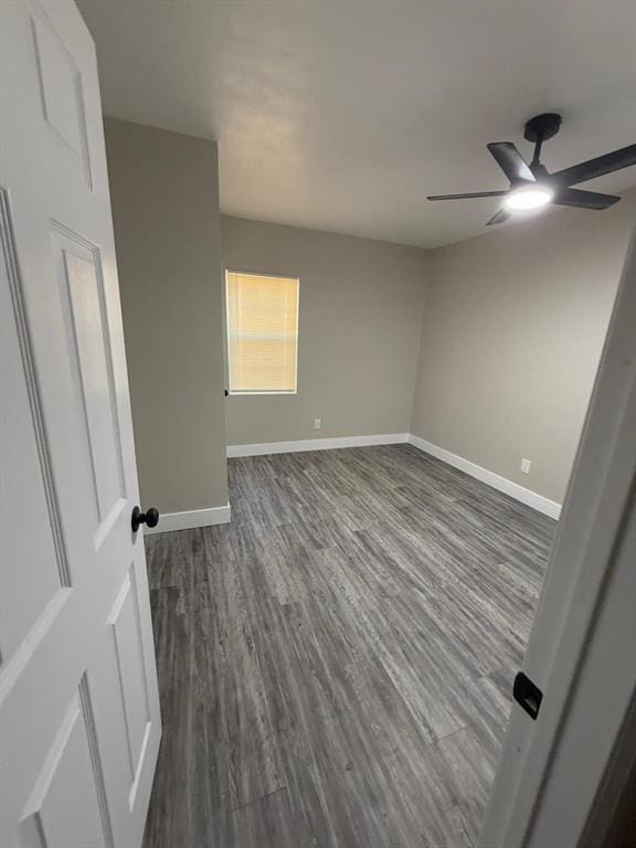 spare room with dark hardwood / wood-style floors and ceiling fan