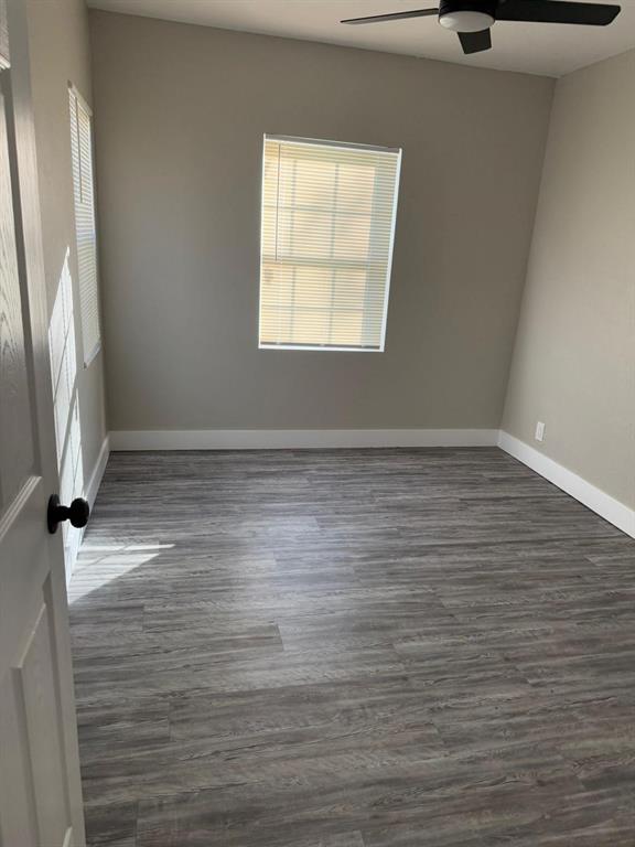 spare room with dark hardwood / wood-style flooring, plenty of natural light, and ceiling fan