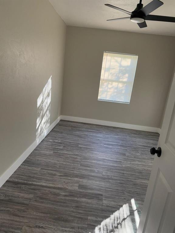 empty room with dark hardwood / wood-style flooring and ceiling fan