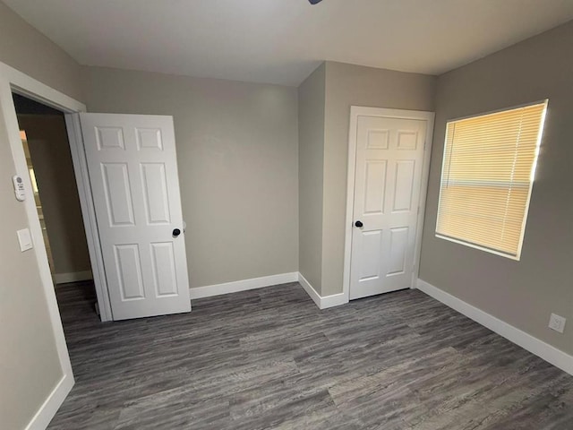 unfurnished bedroom with dark hardwood / wood-style floors