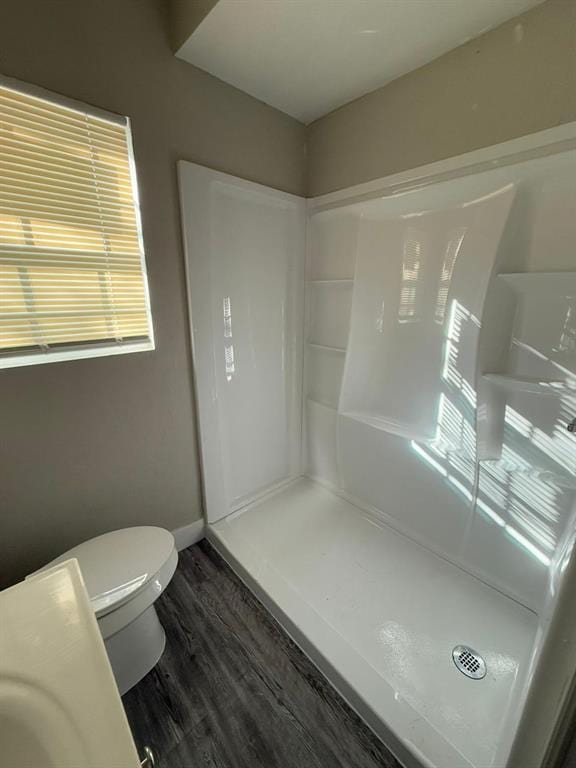 bathroom with hardwood / wood-style floors, toilet, and walk in shower