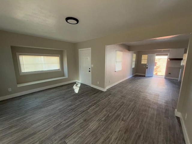 unfurnished living room with dark wood-type flooring