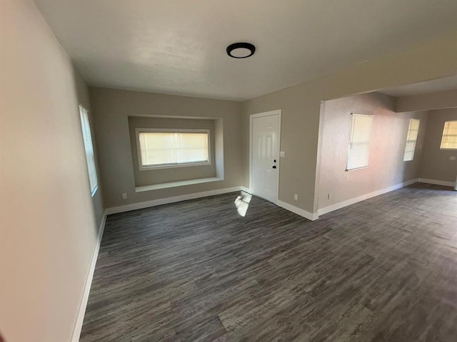 empty room with dark hardwood / wood-style flooring