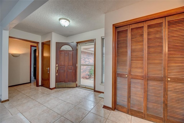 tiled foyer featuring a textured ceiling