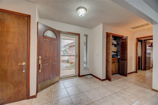 tiled entryway with a textured ceiling