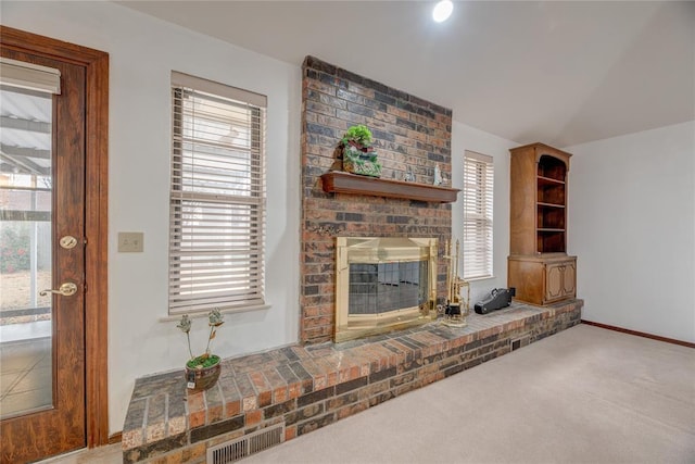 carpeted living room with a brick fireplace