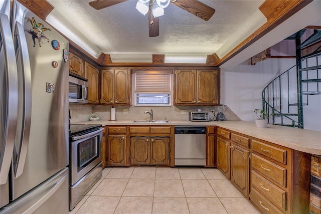 kitchen featuring sink, stainless steel appliances, a textured ceiling, light tile patterned flooring, and decorative backsplash