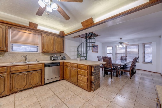 kitchen with light tile patterned flooring, dishwasher, sink, backsplash, and kitchen peninsula