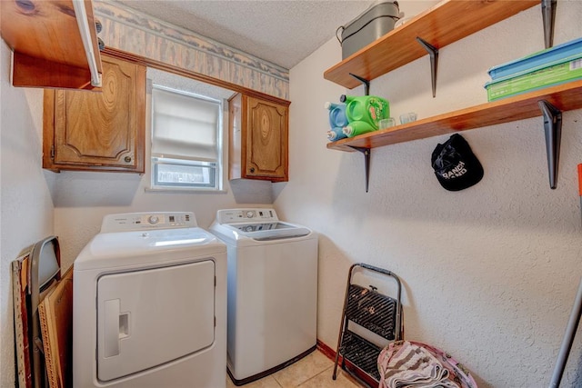 laundry area featuring heating unit, cabinets, washer and dryer, light tile patterned floors, and a textured ceiling