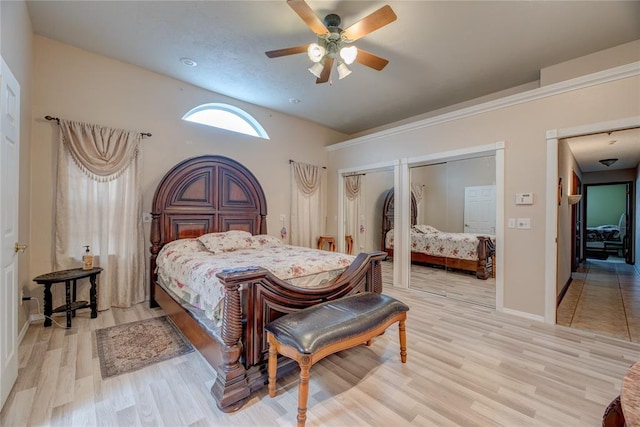 bedroom with ceiling fan, multiple closets, and light wood-type flooring