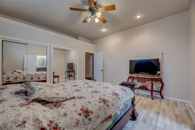 bedroom with multiple closets, ceiling fan, and light hardwood / wood-style floors